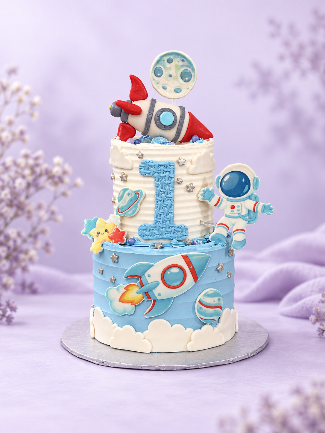 Space-themed first birthday cake with rocket, astronaut and moon decorations